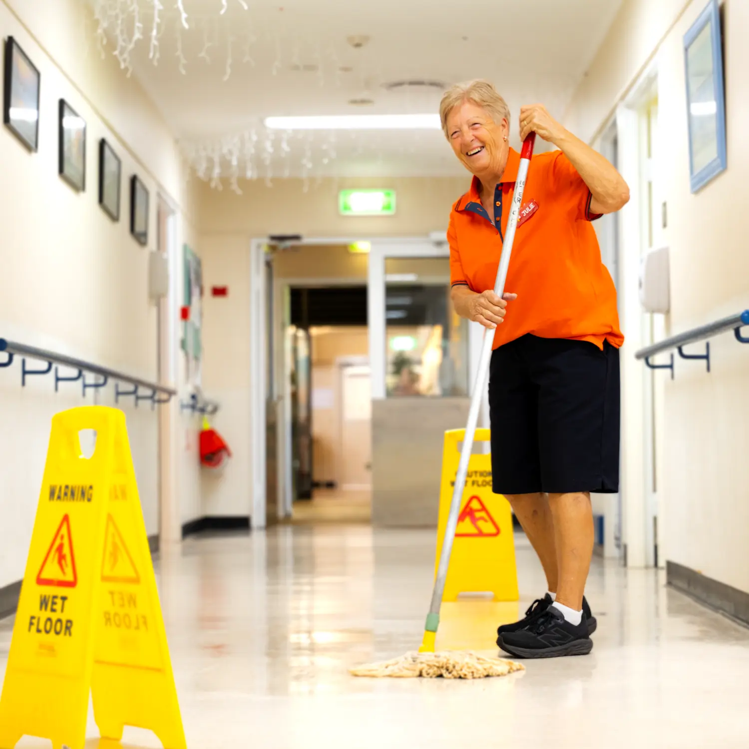Support Services Worker mopping floor.