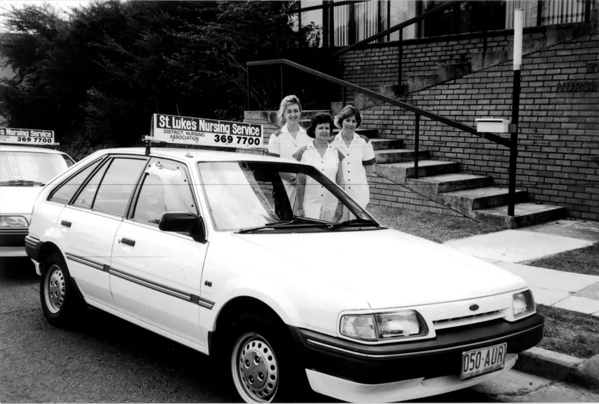 Picture of three Anglicare Southern Queensland nurses standing next to a car outside of St Luke's in the early 1990's.