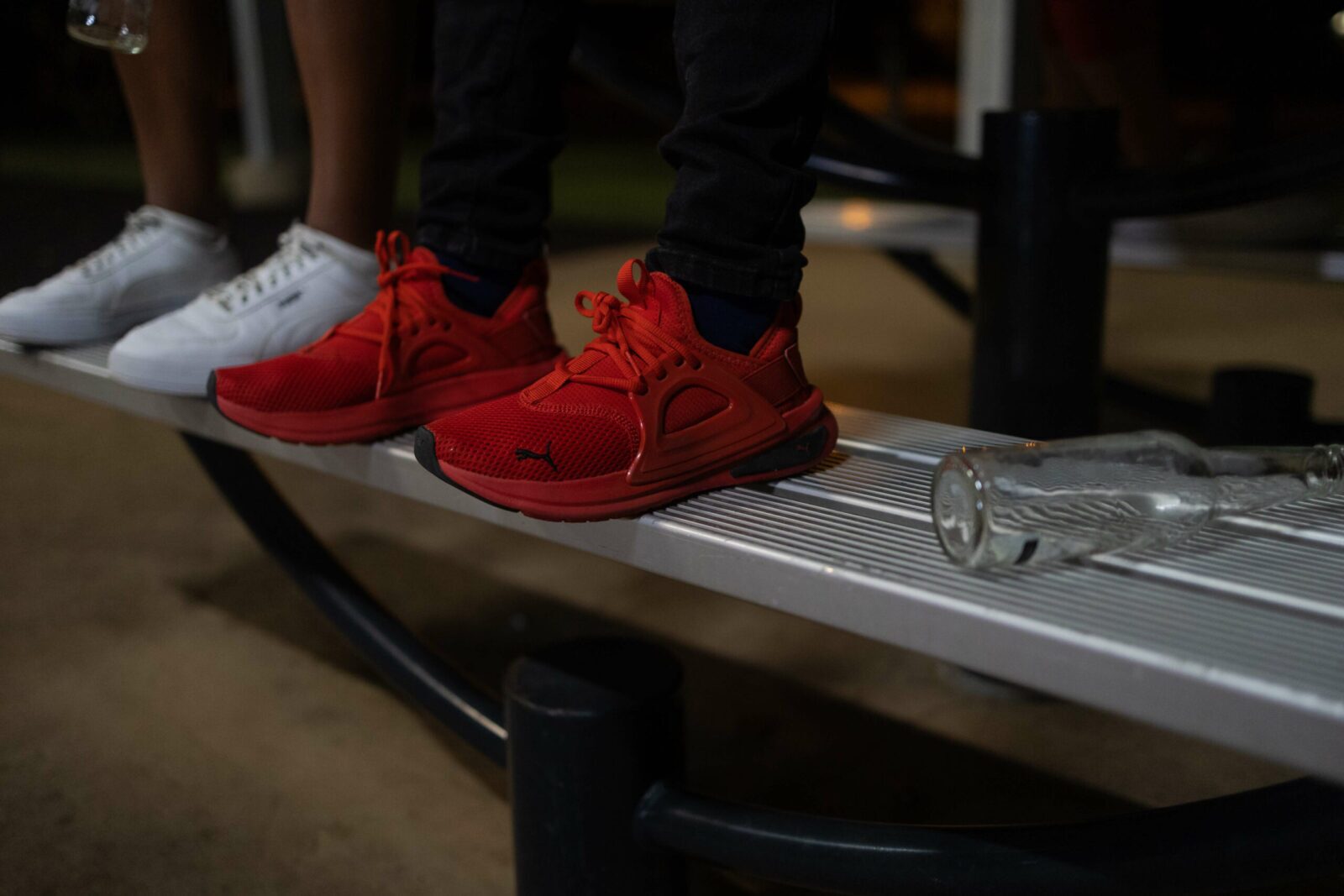 Two young people sitting on a park bench at night before a drug diversion program.