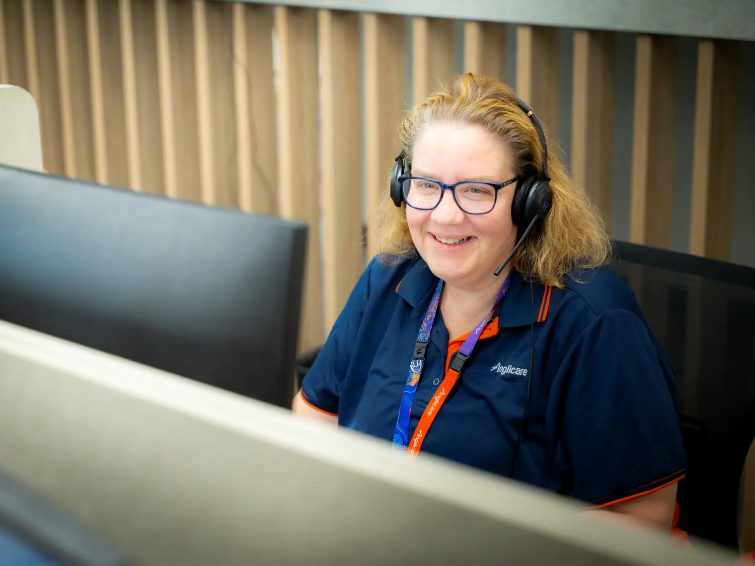 Anglicare staff member speaking on the phone with client