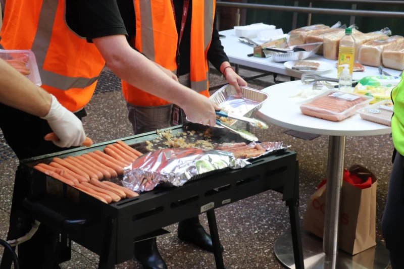 people cooking sausages for a community fundraising event