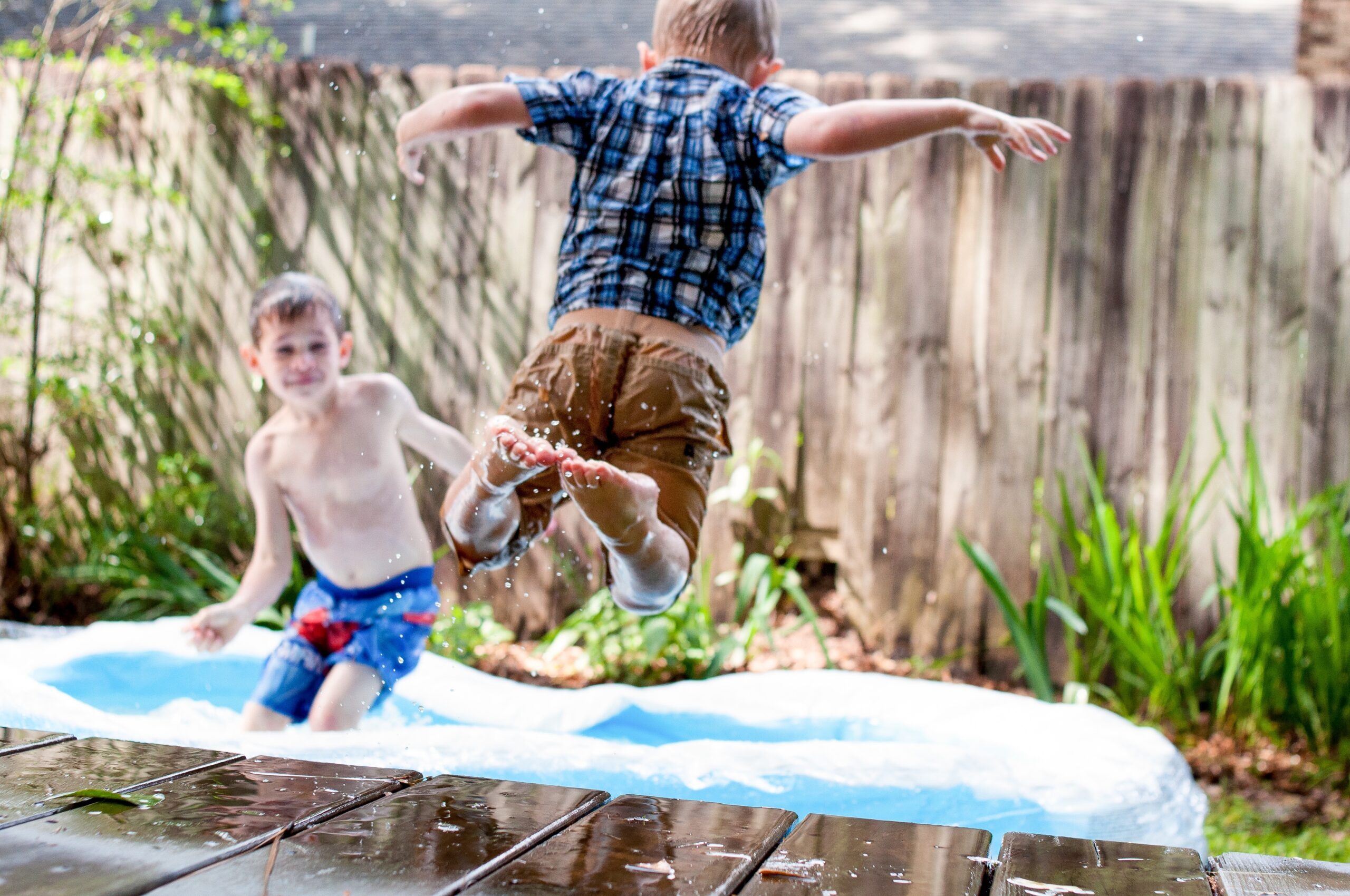 Can I be a full-time foster carer and work full-time:
Image of two young boys playing in the rain