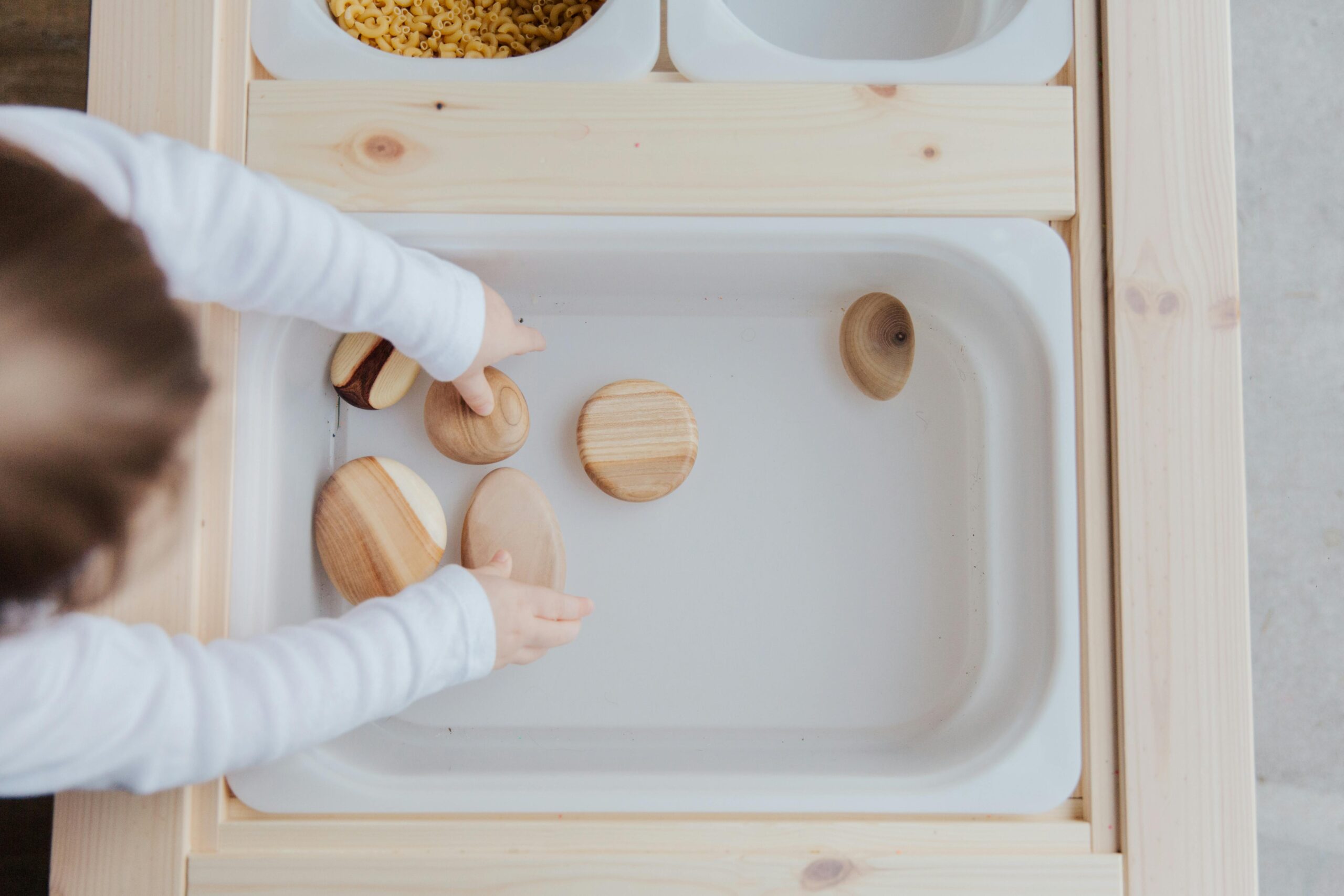 Parenting hack picture: child playing with rocks in a busy board