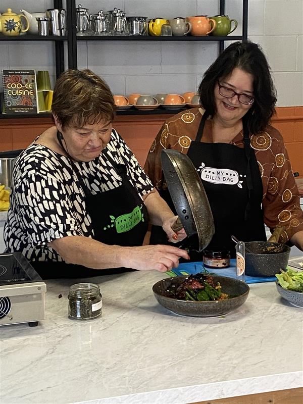 Anglicare CEO Sue Cooke and Aunty Dale Chapman cooking during NAIDOC Week 2024