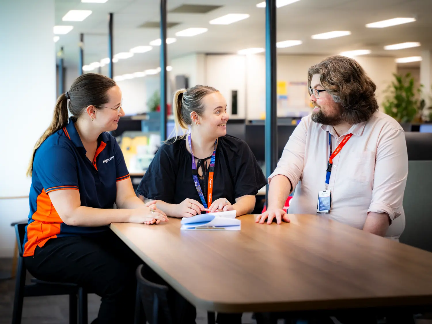 Anglicare workers collaborating on project in office.