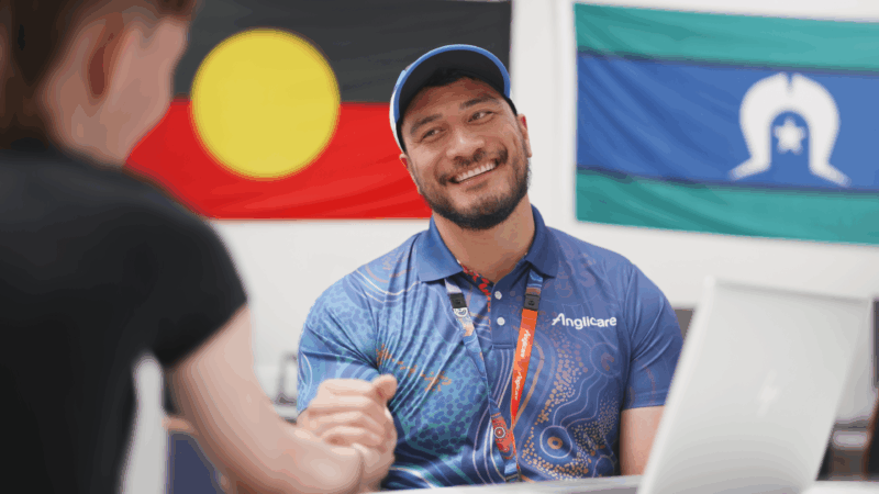Homelessness practitioner smiling at client, representing Anglicare's homelessness service