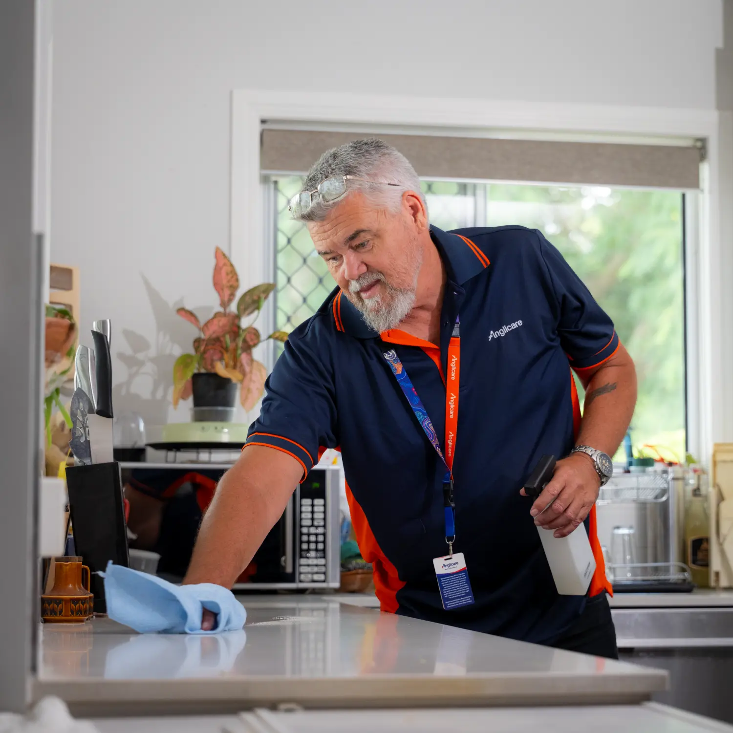 Support Services Worker proving domestic assistance by cleaning kitchen for client