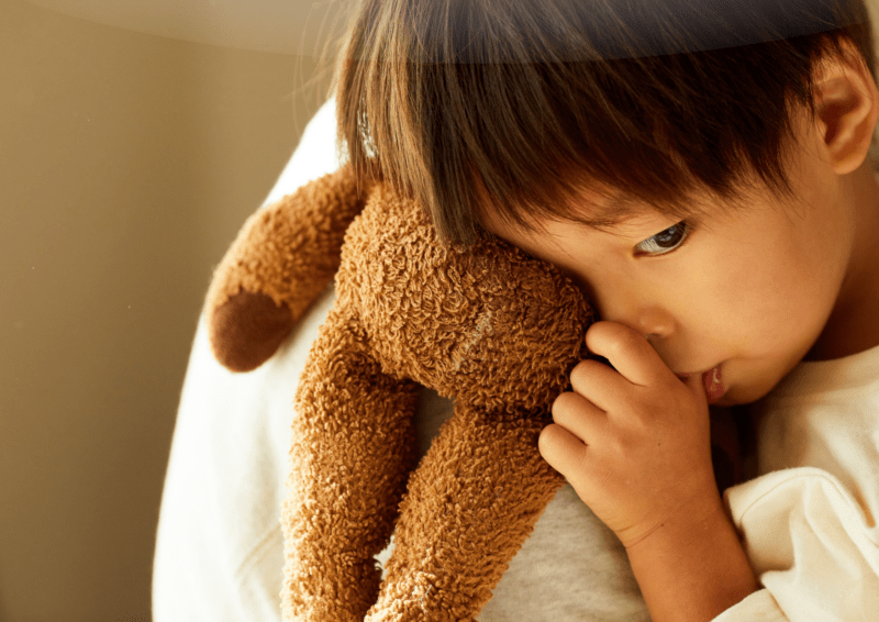 Foster carer soothing a young child in distress.