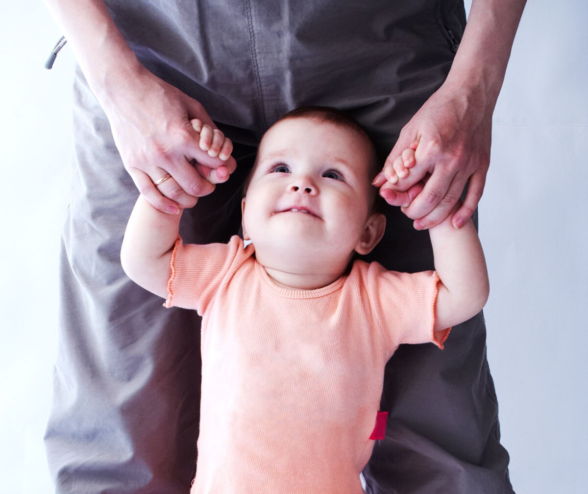 Peter holding small toddlers arms to help stand