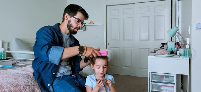 Father brushing daughters hair