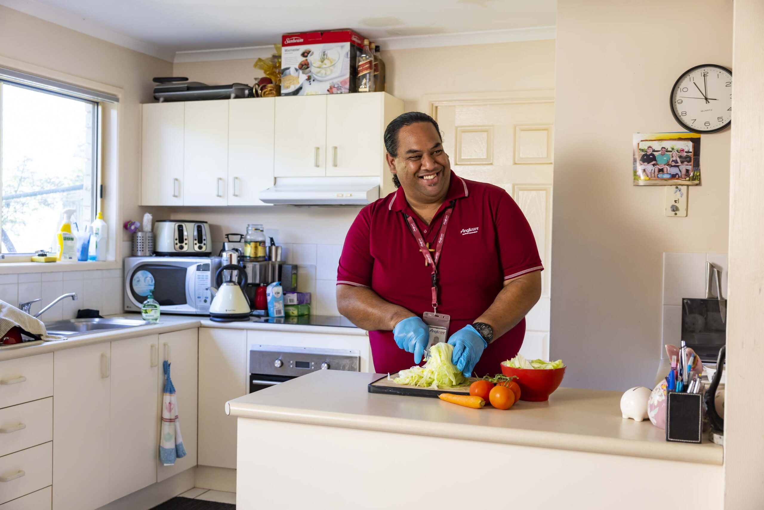 Home care worker cutting up vegetables in clients kitchen