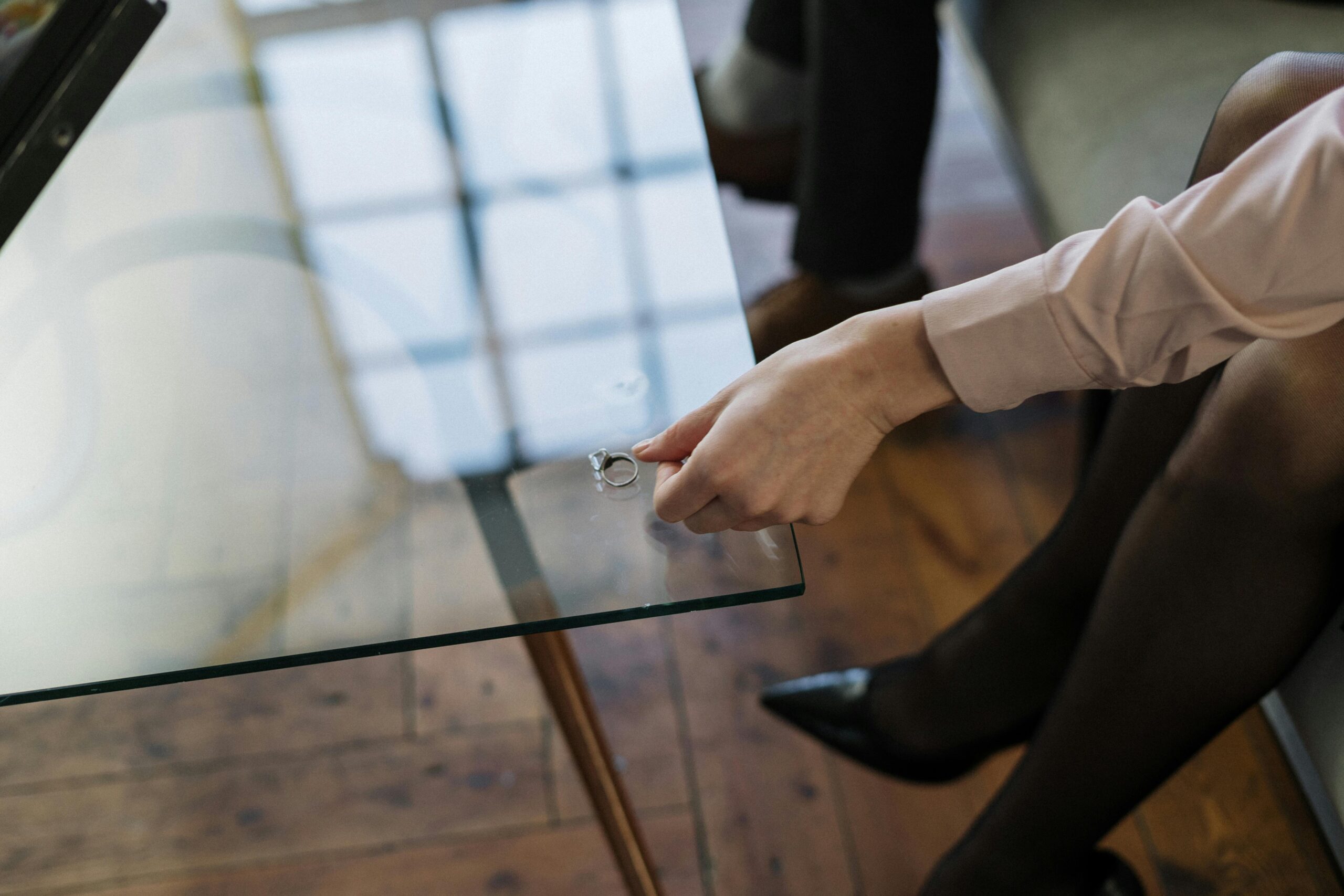 Learn how to deal with separation and divorce. Image of lady putting her wedding ring down on a glass table.