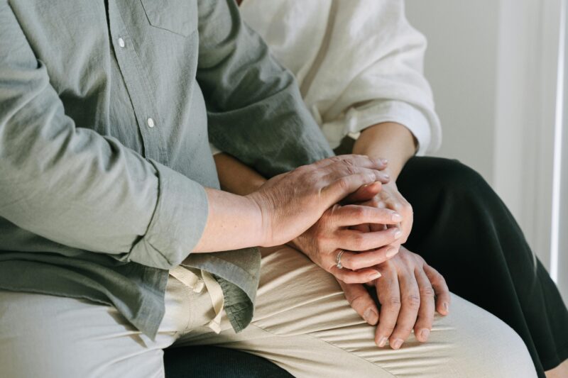 Attachment styles blog: couple sitting down close to each other and holding hands