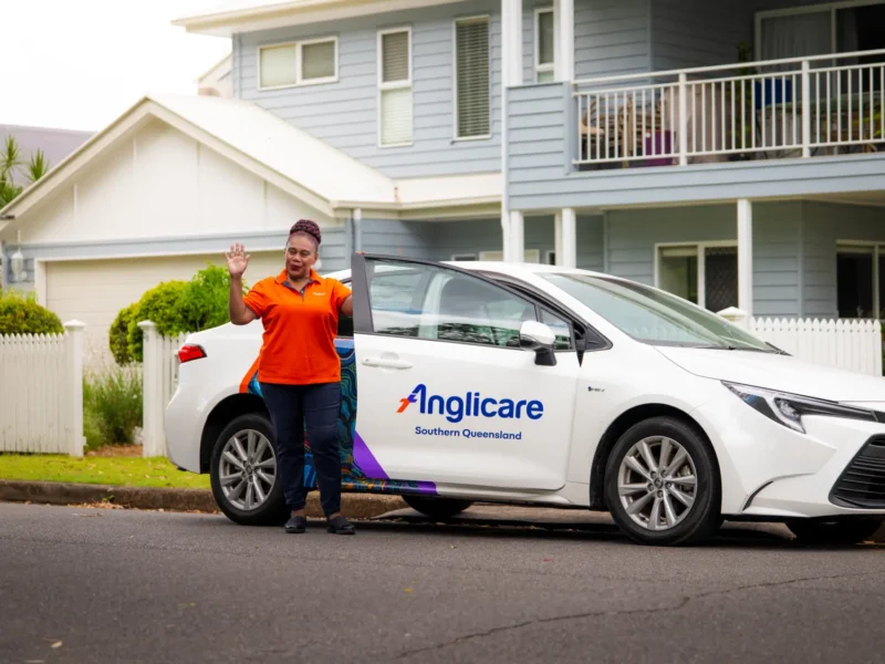 Anglicare Support at Home worker waving to client from car
