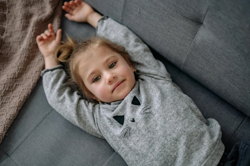Young child relaxing at home and building resilience through mindfulness and relaxation.