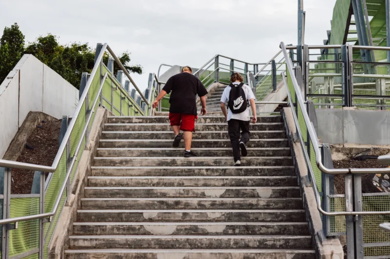 Two young boys walking up stairs at train station.