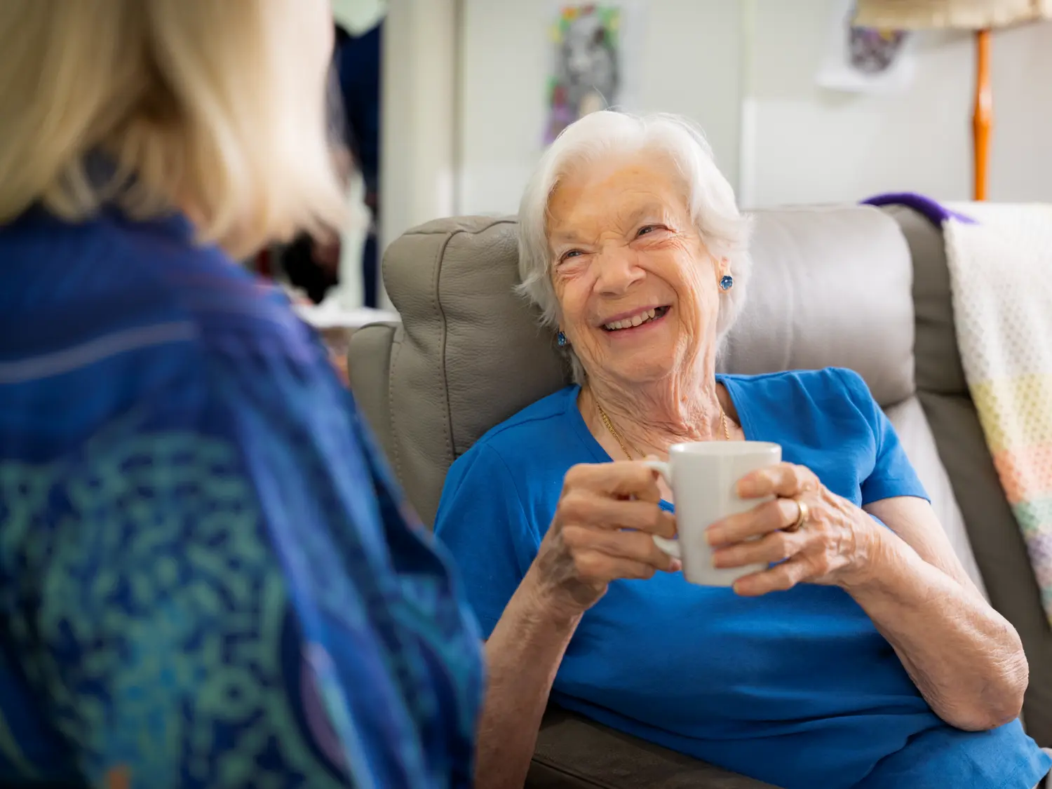 Social group playing a game at a day respite centre with staff member watching in the background.