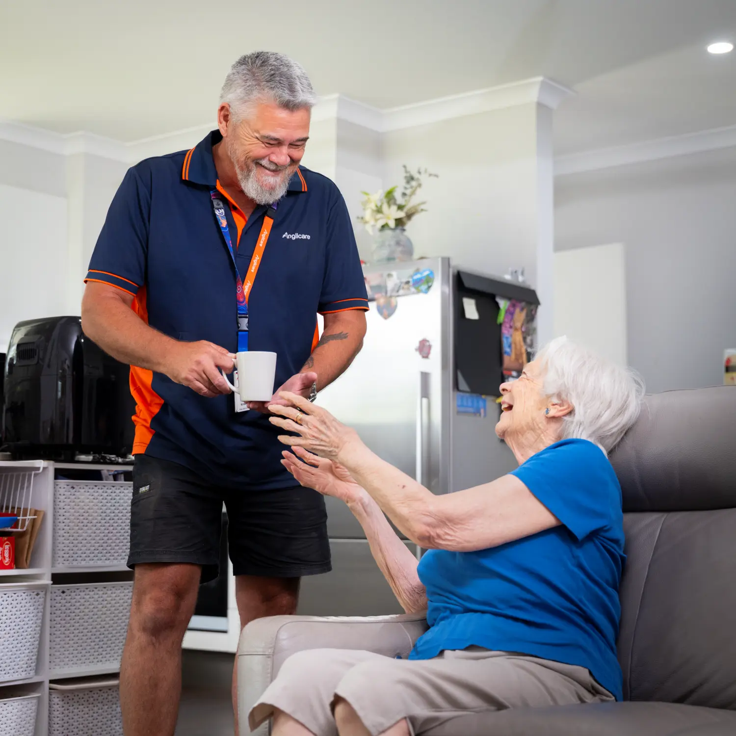Anglicare worker giving tea to elderly female client in her home.