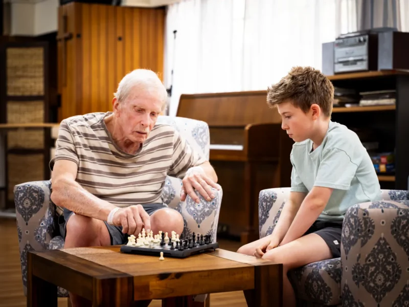 Boy playing chess with St Martin's elderly resident for Anglicare's intergenerational program