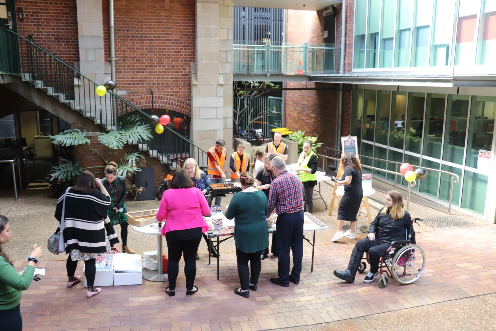 group of people in a courtyard setting up a fundraising event