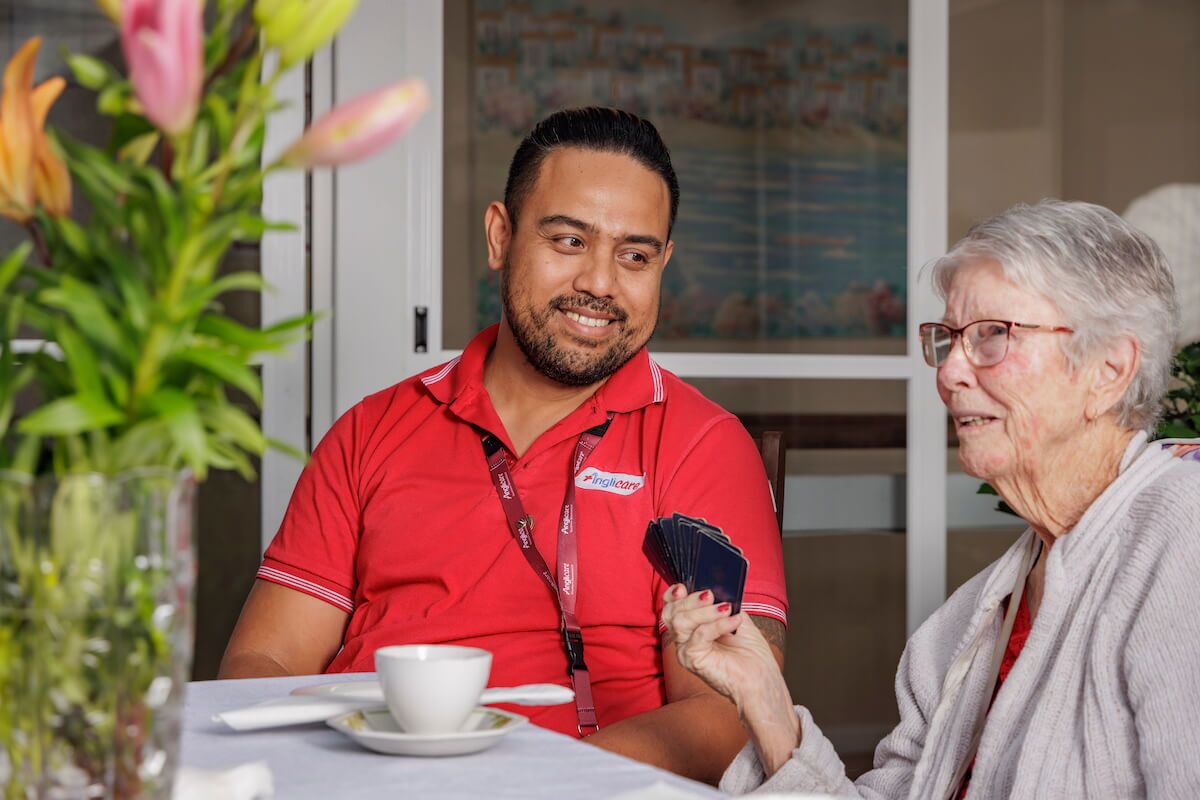 Anglicare staff member playing cards with client
