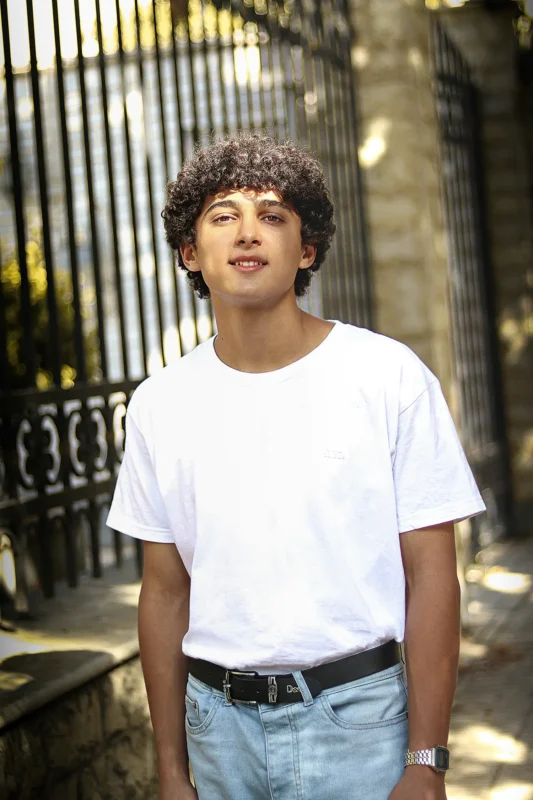 Teenager in foster care smiling confidently outdoors, representing youth voice and participation in Queensland foster care discussions.