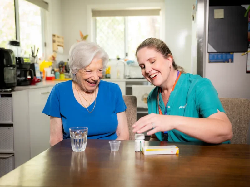 Anglicare nurse helping elderly female client with medication
