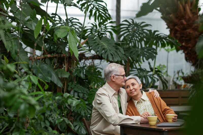 Attachment styles blog. Middle aged couple cuddling while enjoying coffee in garden