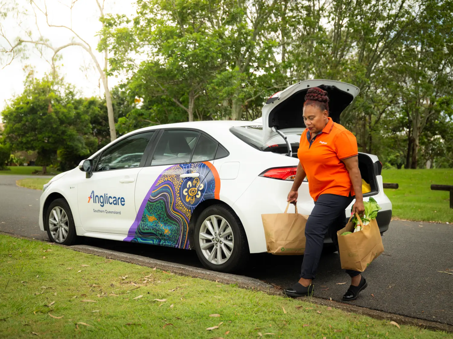 Anglicare worker carrying groceries from car
