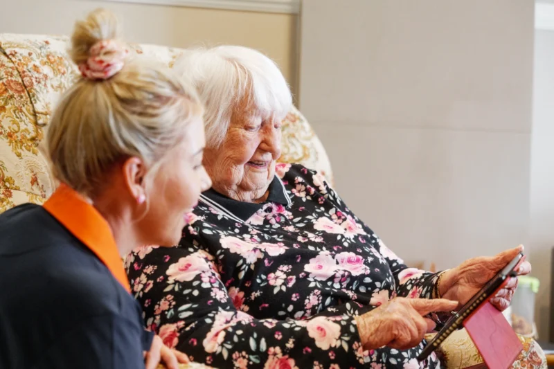 Care worker showing client how aged care reforms improve access, communication and quality of care.