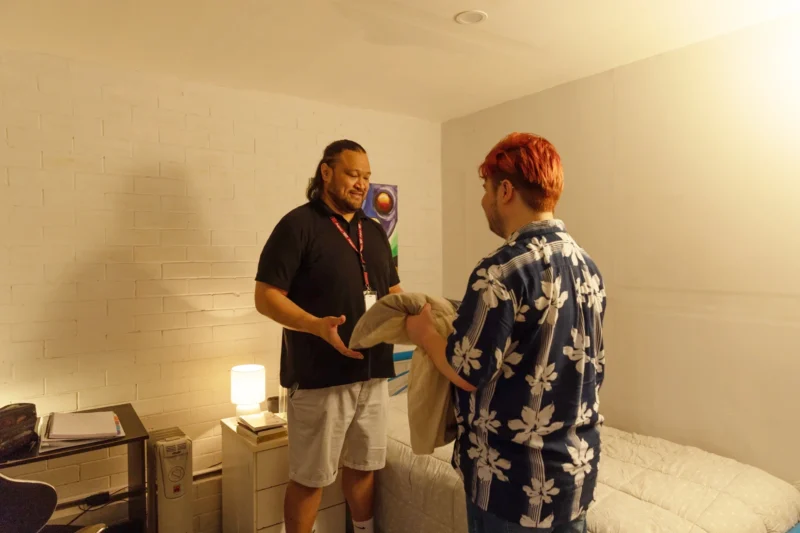 Young client being shown his new room in one of Anglicare's youth homelessness accommodation homes by a male youth worker.