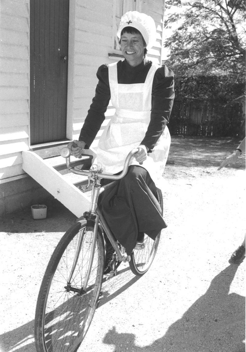 Matron Val Gibbs reenacting the first nurse Emma Jane Packer on her bike