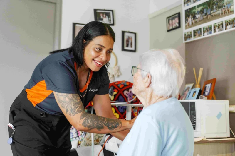 Respite carer assisting an elderly woman during residential respite care.