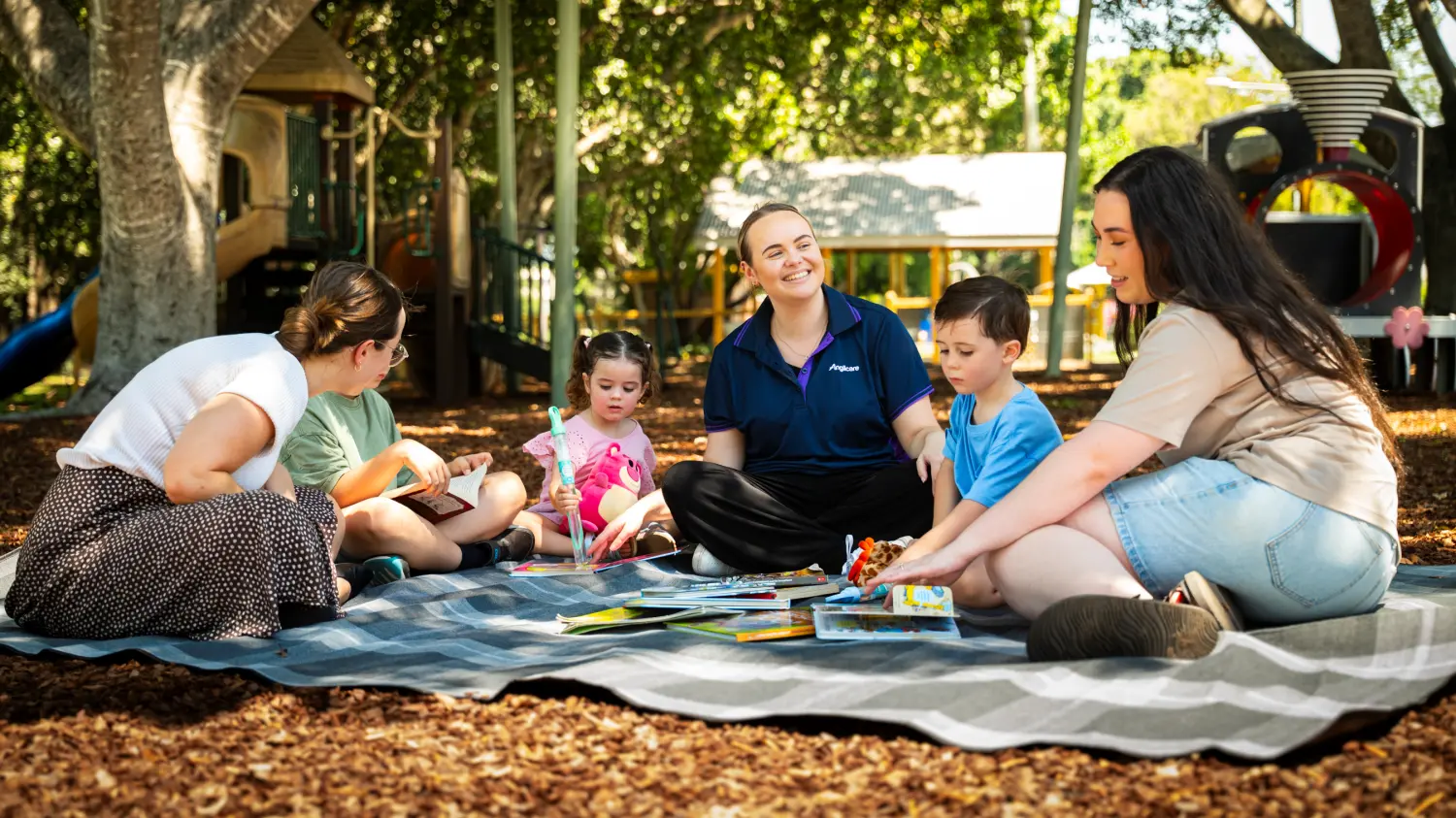 Mothers and their young children playing on a playmat.