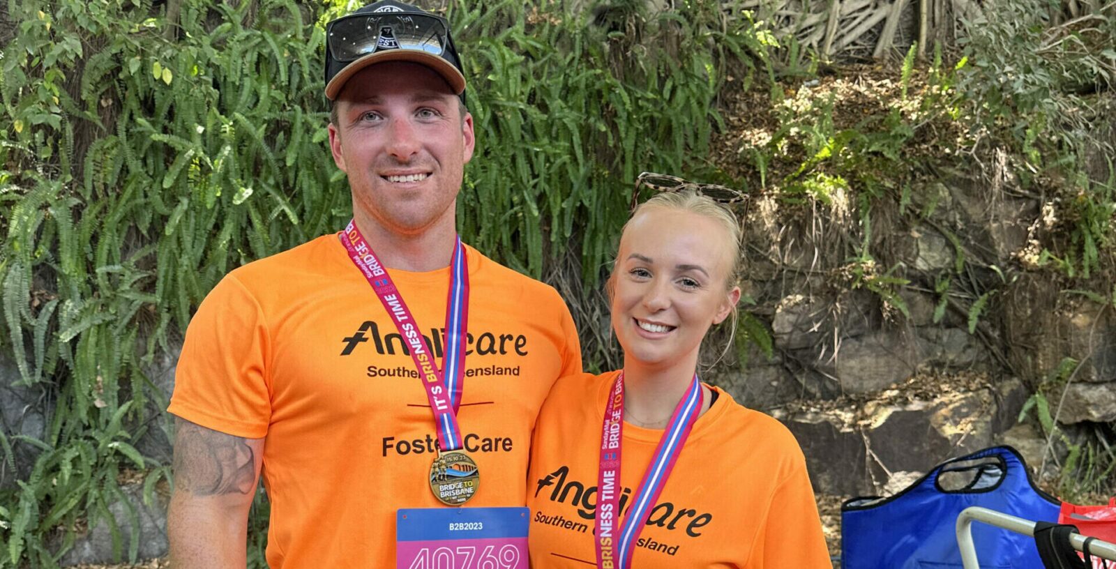 two people smiling wearing fundraising shirts and medals after participating in a race