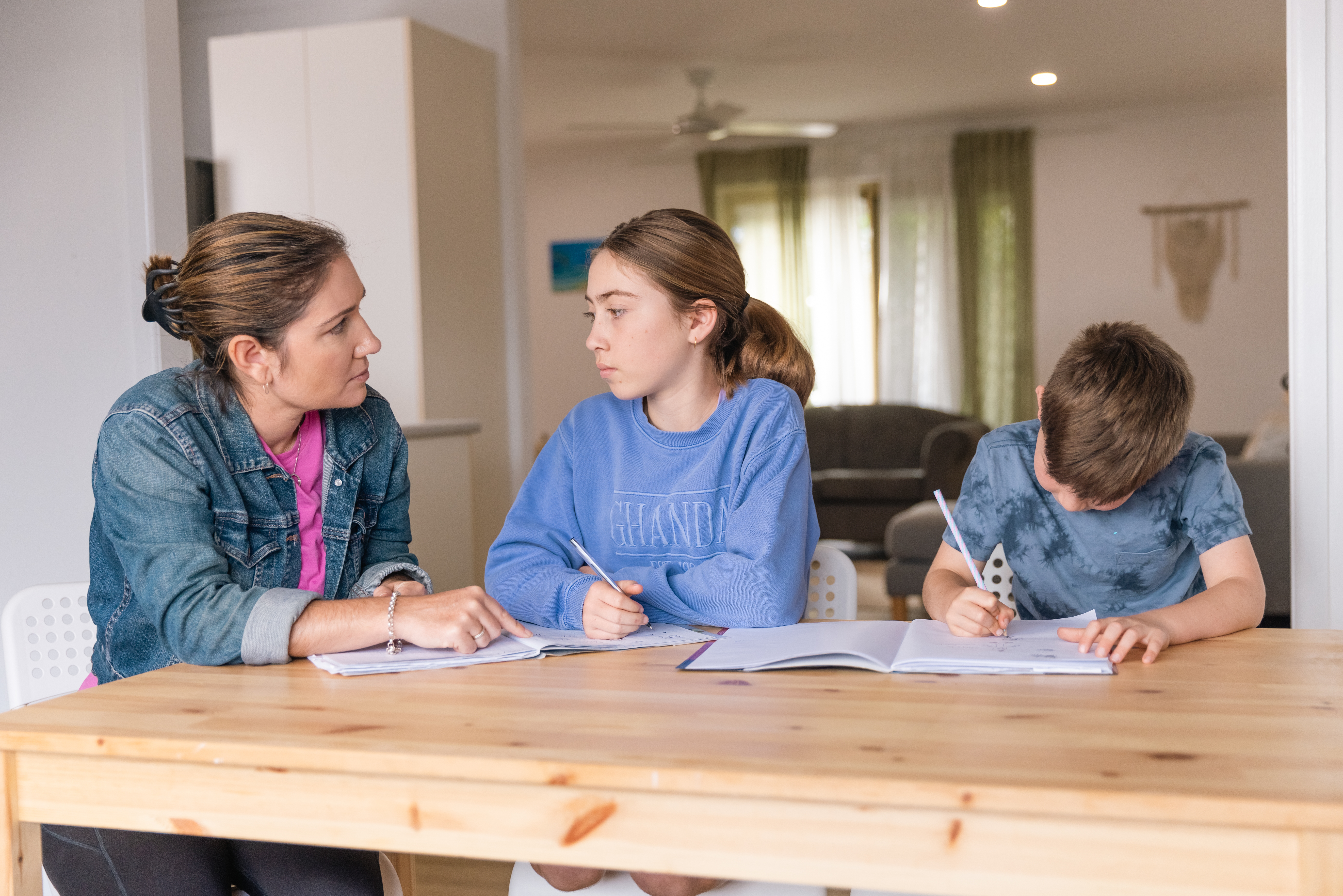 Mother helping her son and daughter do homework