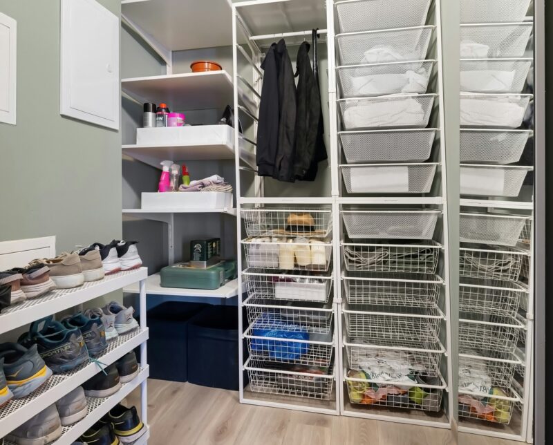 Person creating an organised household by keeping a tidy cupboard